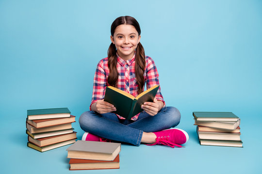 Portrait of nice attractive lovely intellectual cheerful girl nerd wearing checked shirt sitting in lotus pose library academic reading house isolated over bright vivid shine blue turquoise background