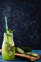 Fresh lemonade with kiwi and cucumber on a black. Refreshment water. Copy space