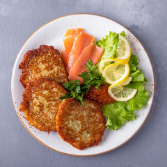 Fried potato pancakes with caviar and salmon on a plate.. Top view. Closeup photo