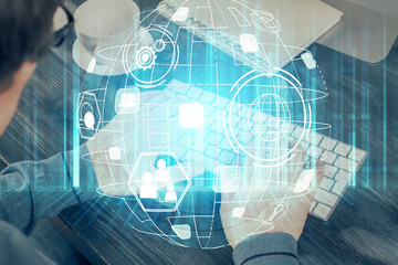 Social network theme hologram with businessman working on computer on background. Multi exposure.
