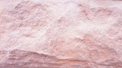 Unevenly treated surface of a pinkish-colored stone