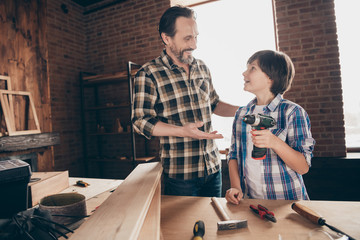 Portrait of two nice person cheerful woodworkers master handyman sharing experience skills showing...