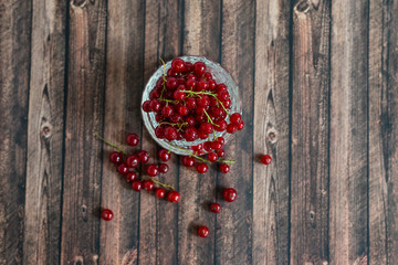 Red currant on brown wooden table.