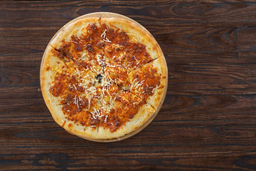 Pizza with cheese. Close-up, overhead view, wooden table