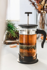 Teapot with herbal tea on white surface