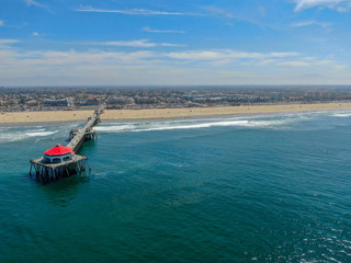 Naklejka premium Aerial view of Huntington Pier, beach & coastline during sunny summer day, Southeast of Los Angeles. California. destination for surfer and tourist.
