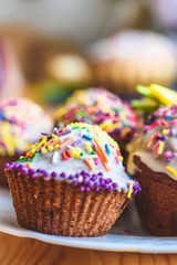 Cupcakes with multi-colored sprinkles close-up. Easter Day celebration. Holiday dinner