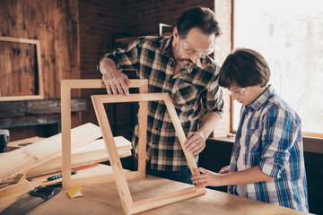 Portrait of focused concentrated youth daddy son kid hold hand furniture diy interested workstation...