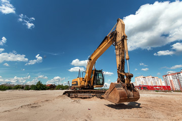 Excavator on a construction site against a blue sky. Construction, technology
