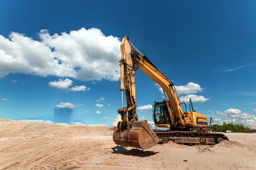 Excavator on a construction site against a blue sky. Construction, technology