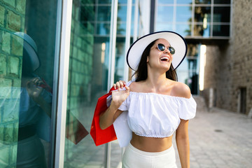 Shopping and tourism concept. Happy young oman with shopping bags