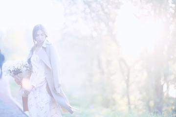 girl holding a bouquet of flowers a walk in the park / romantic young beautiful cute model, love feelings gift
