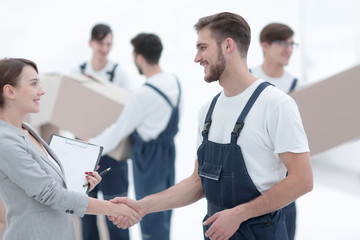 Manager with clipboard shaking hands with movers.