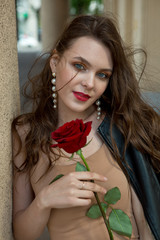 Beautiful girl on a walk in the street in a leather jacket with bright makeup