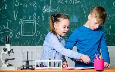 Girl and boy smart students conduct school experiment. Chemical analysis. Kids busy study...