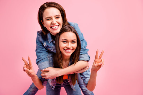 Close up photo two beautiful funky sisters she her best ladies party chill mood hugging v-sign symbol say hi hello piggyback posing wear jeans denim jackets blazers isolated bright pink background