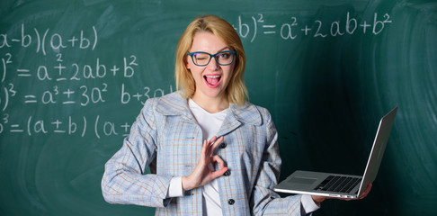 Online schooling concept. Woman wear eyeglasses holds laptop surfing internet. Educational site for...