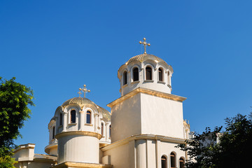 Golden domes with a crosses on the Christian Orthodox Church shine on a sunny day against blue sky. Greek and Balkan church architectural style. Christianity and orthodox christianity.