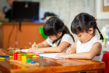 Fototapeta premium Preschooler child girl drawing and coloring