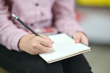 Female writing on notebook.