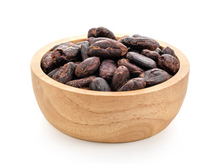 Group of roasted unpeeled cocoa beans in wood bowl isolated on white background