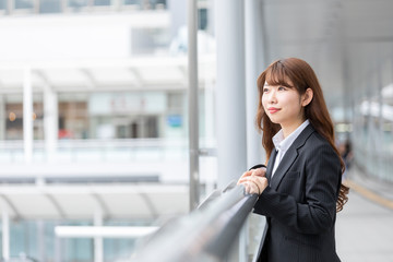 遠くを見つめるスーツを着た若い女性