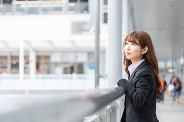 遠くを見つめるスーツを着た若い女性