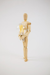 Wooden puppet with light bulb in white background.Wooden mannequin figure taking the first step  to his goal- career, growth or development concept.