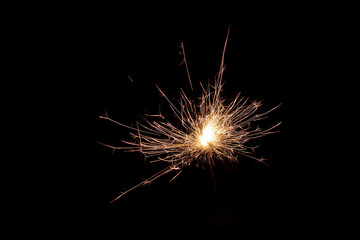 Close up shot of firework sparkler burning, burning sparkler isolated on black background