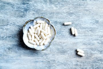 Theanine capsules. Dietary supplement.   Rustic wooden background. Top view. Copy space. 