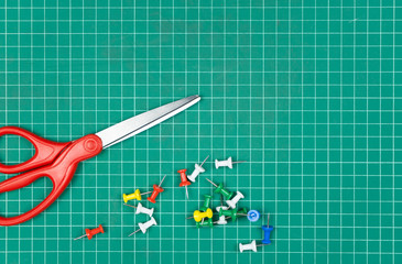 Scissors and Green Cutting mat on desk.