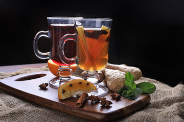 Two glasses of hot mulled wine with spices and ginger on wood. - 275248745