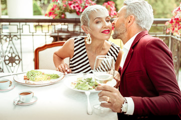 Husband kissing his wife while having romantic dinner