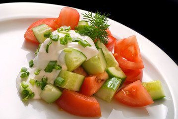 Salad with sour cream, onions, tomatoes and cucumbers, close up