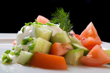 Salad with sour cream, onions, tomatoes and cucumbers, close up