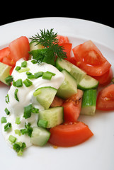 Salad with sour cream, onions, tomatoes and cucumbers, close up