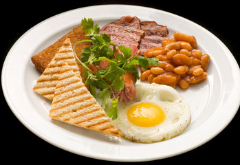 English breakfast: fried egg, bacon, beans and toast on a plate close-up.