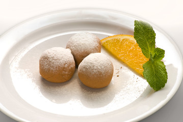 Chocolate truffle with organic cacao on a white plate decorated with fruits and berries