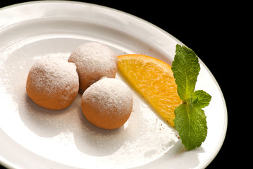 Chocolate truffle with organic cacao on a white plate decorated with fruits and berries
