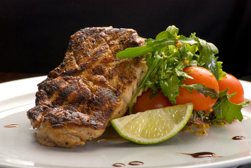 Well-done steak with suace and vagetables. Reastaurant dishes on the wooden table. Food photo for restaurant menu. Selective focus.