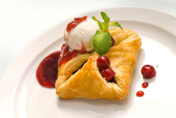 photo of delicious puff pastry with berries and ice cream on a white plate