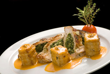 Turkey stuffed with spinach with couscous on a white plate