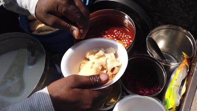 Street food- Dahi bhalla and Papri chaat, paapri or papdi, popular traditional fast food using crisp fried dough wafers in India, Bangladesh and Pakistan. 4k slow-motion close-up stabilized handheld
