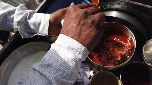 Street food- Dahi bhalla and Papri chaat, paapri or papdi, popular traditional fast food using crisp fried dough wafers in India, Bangladesh and Pakistan. 4k slow-motion close-up stabilized handheld