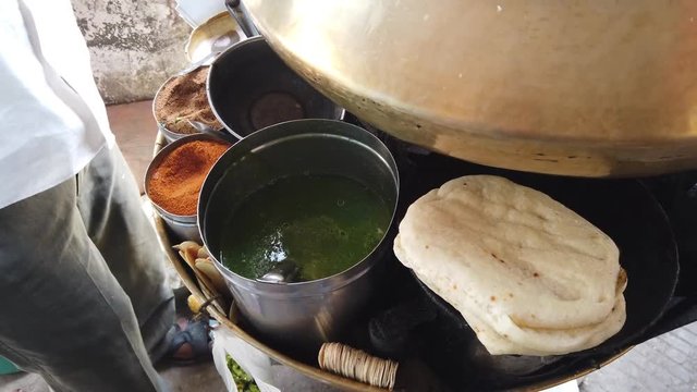 Street food- Chole Kulche- popular fast meal with dry chickpeas spicy masala mixture with maida based bread Kulcha in India, Pakistan and Bangladesh.  4k slow-motion close-up stabilized handheld 