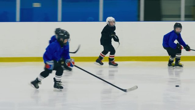 Panning shot of dynamic child ice hockey match