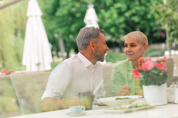 Couple of mature husband and wife enjoying breakfast outside