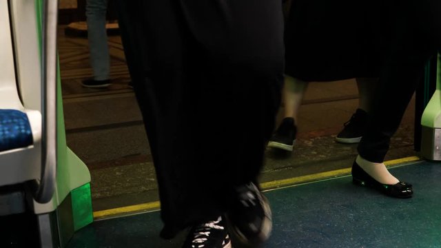 At the metro station, some people get out of the train car, while others enter.