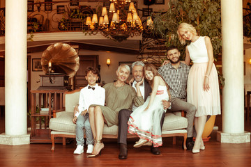 Big family siting on sofa while spending weekend together