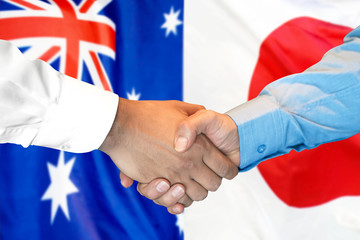 Business handshake on the background of two flags. Men handshake on the background of the Australia and Japan flag. Support concept